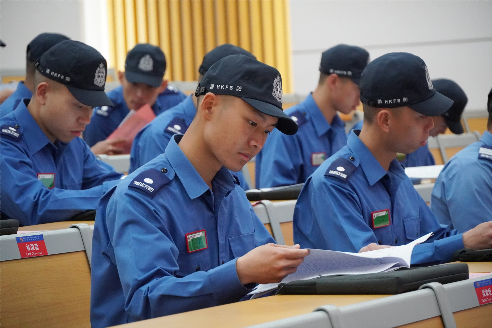 開班儀式上，香港消防處消防及救護學院學員瀏覽培訓手冊。王雅蝶 攝